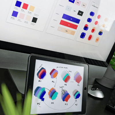 Close up of a laptop and ipad screen with mockups of color and design for branding guide